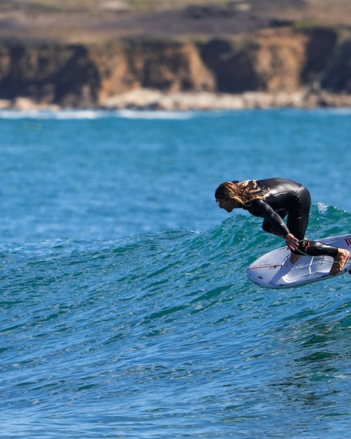 Une personne chevauchant une planche de surf sur une vague